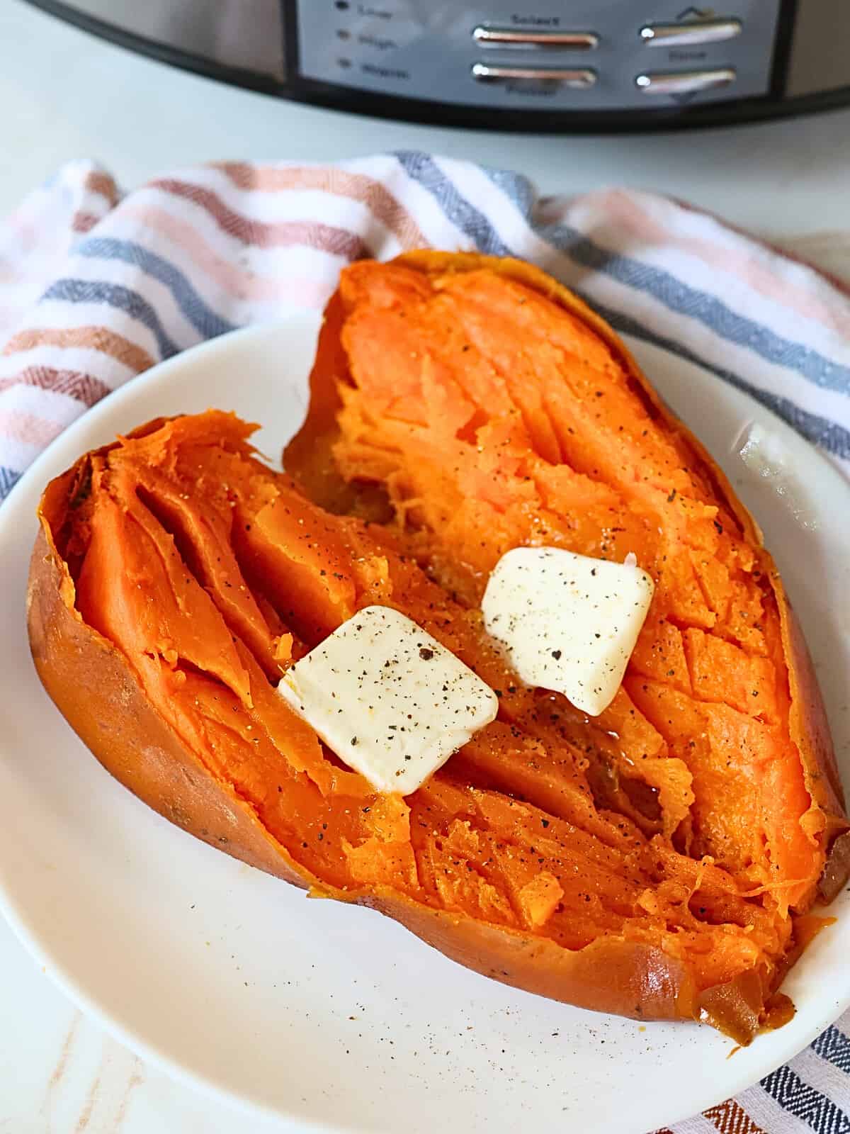 slow cooked whole sweet potato topped with butter