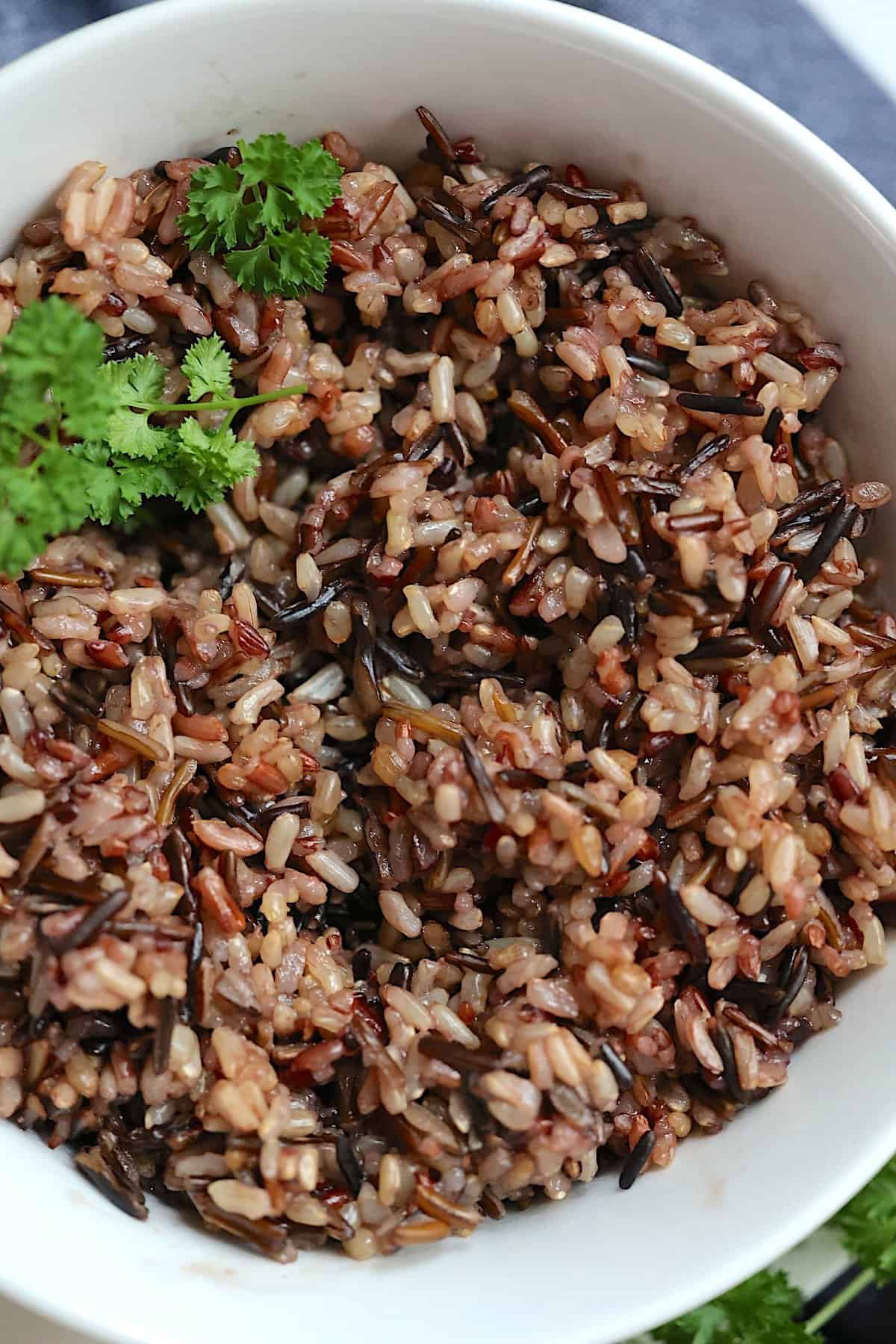 pressure cooked plain wild rice blend in a white bowl with parsley