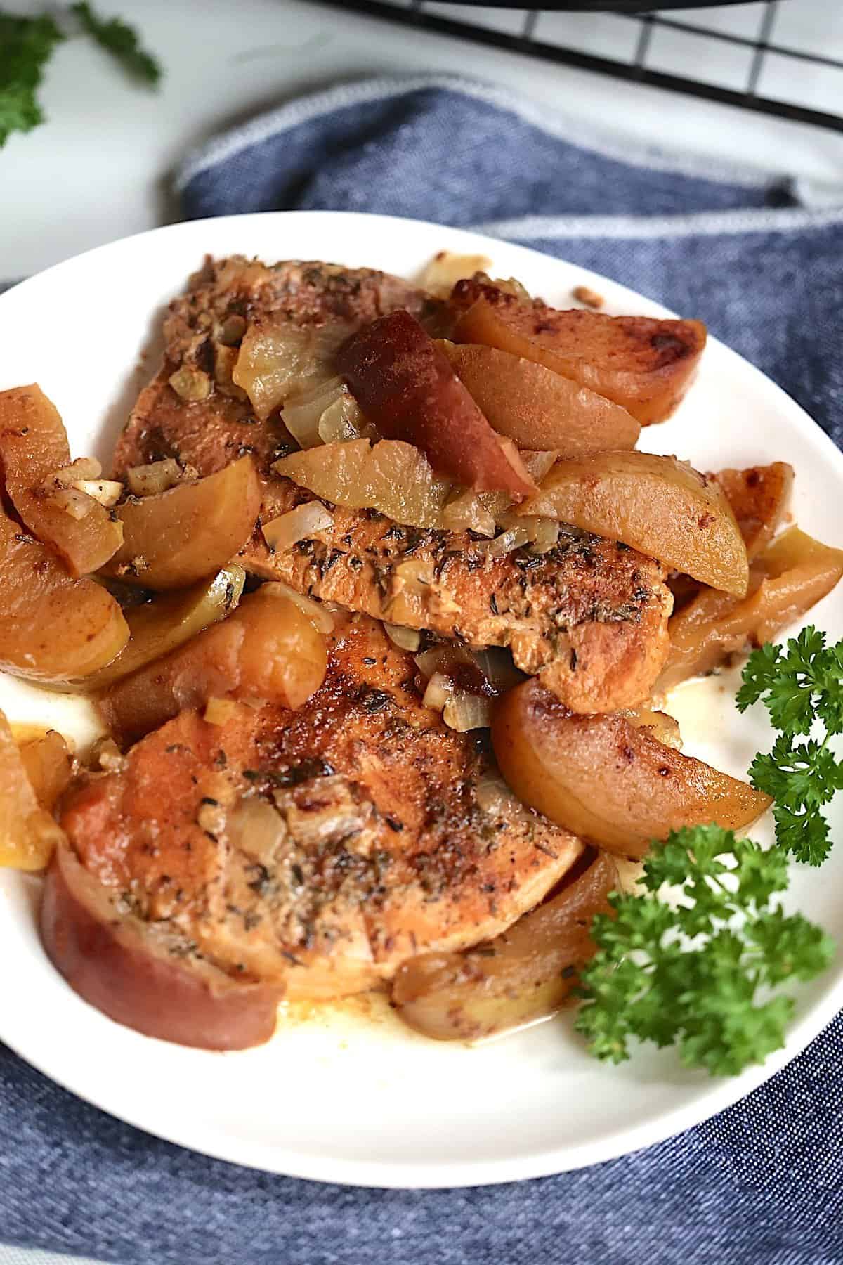 slow cooker pork chops and apples on a white plate