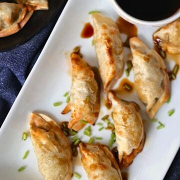 air fried frozen potstickers on a white plate with soy sauce