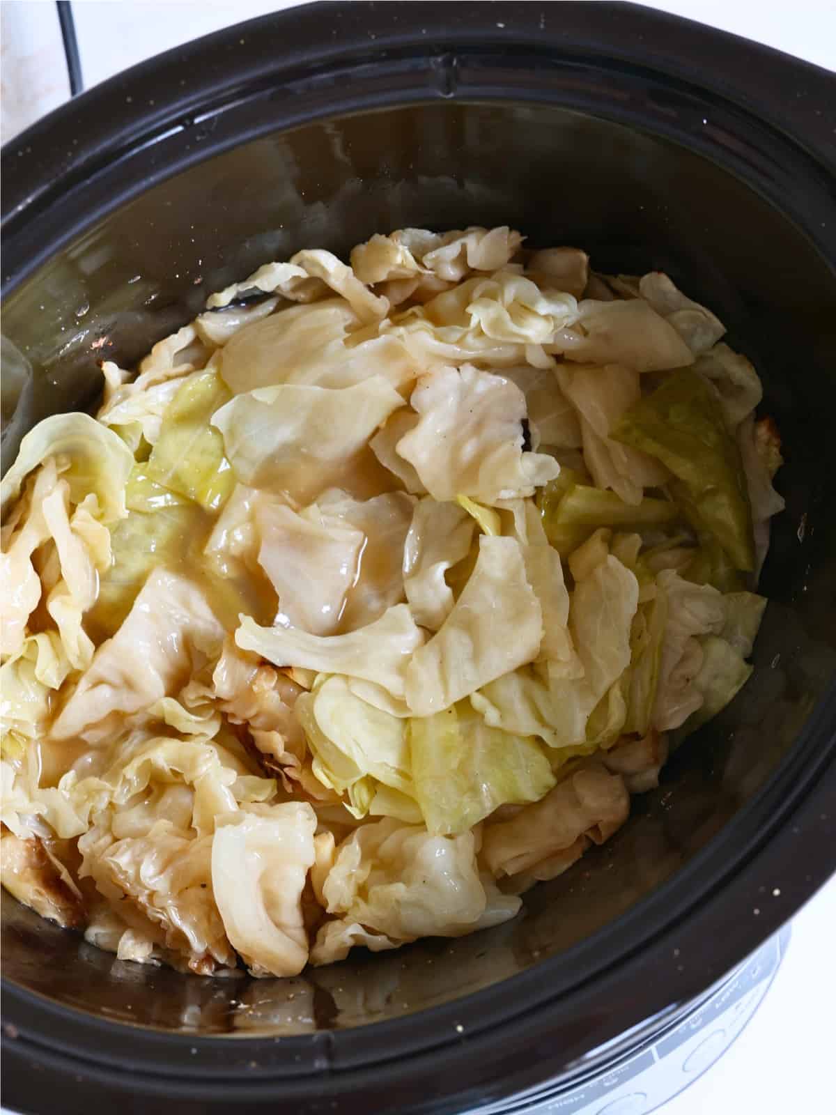 cooked cabbage side dish in a slow cooker with butter and garlic