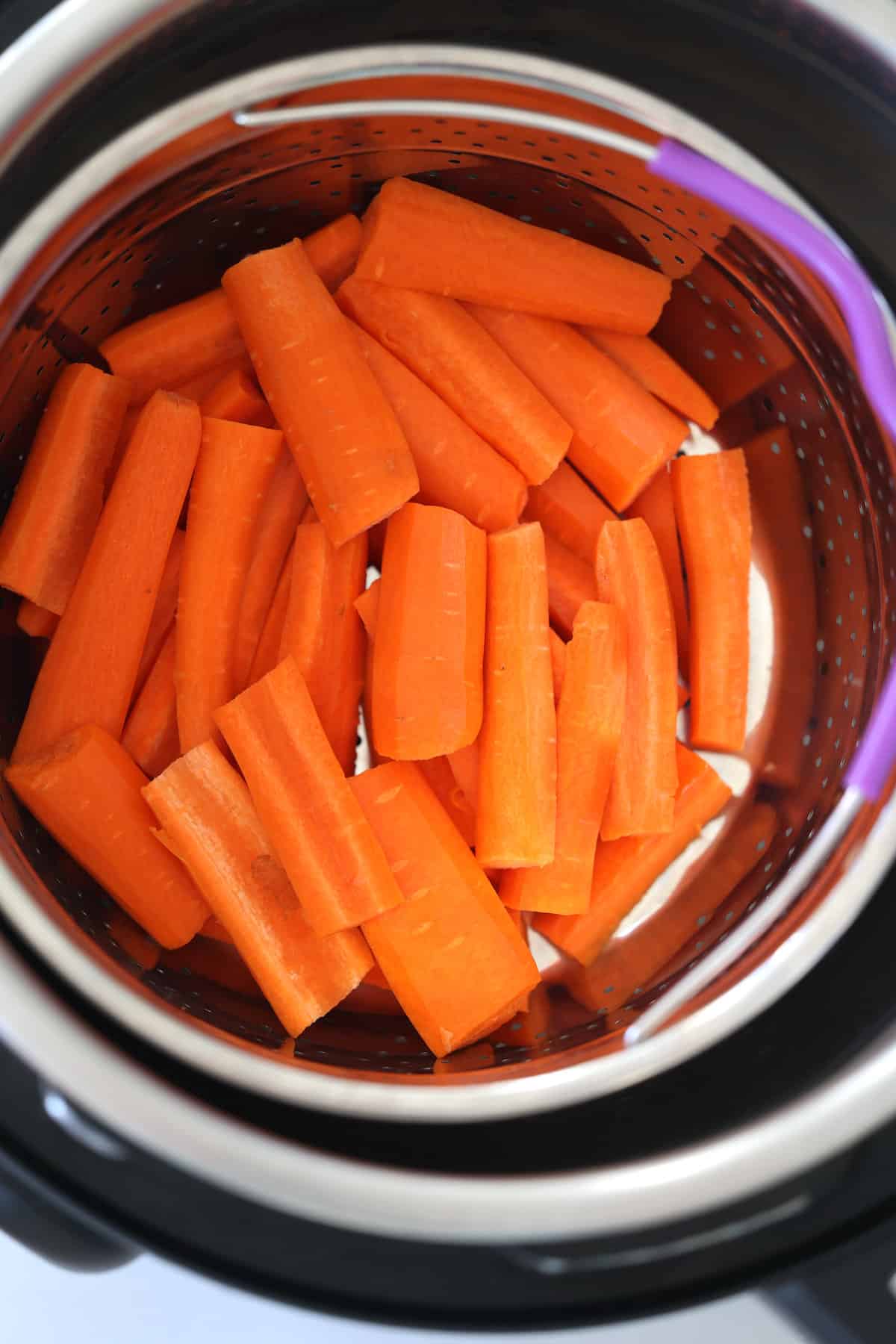 sliced carrots in a steamer basket in a pressure cooker