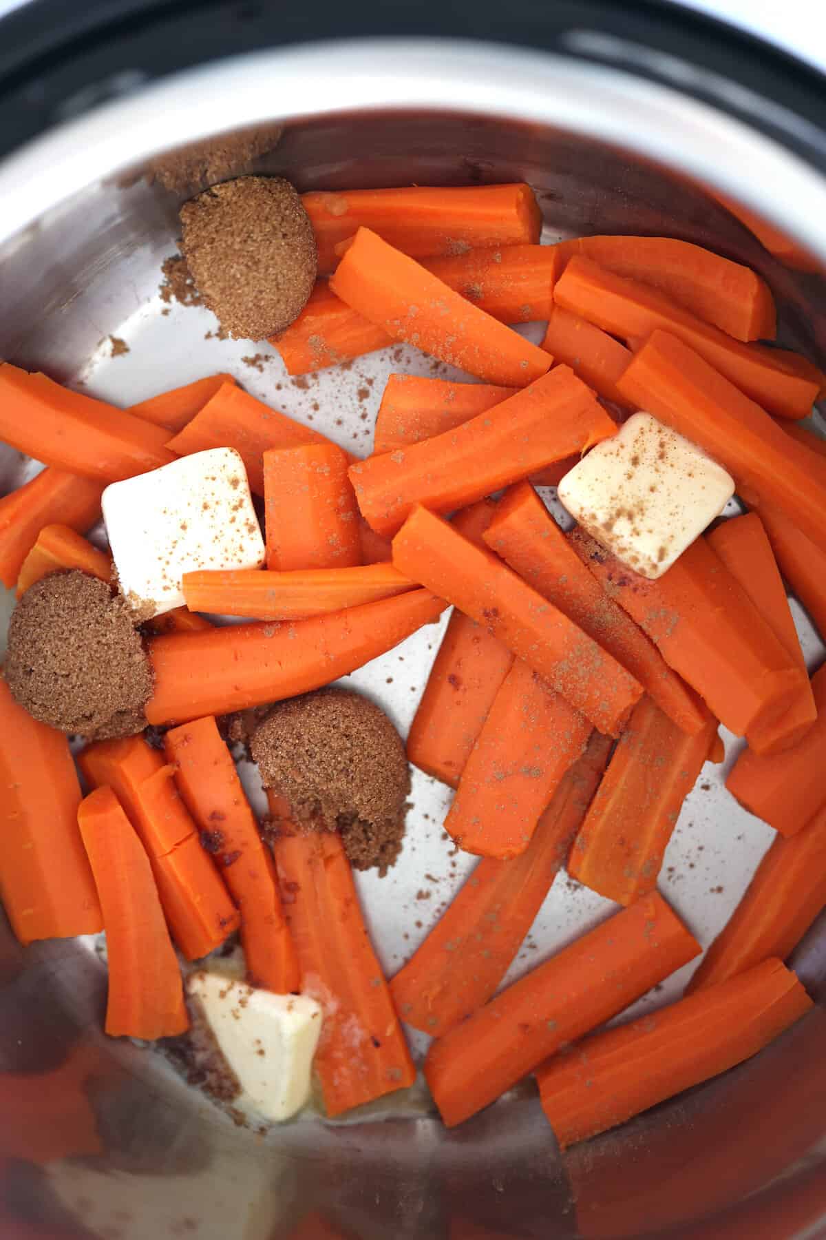 cooked carrots in the instant pot mixed with butter, brown sugar and cinnamon