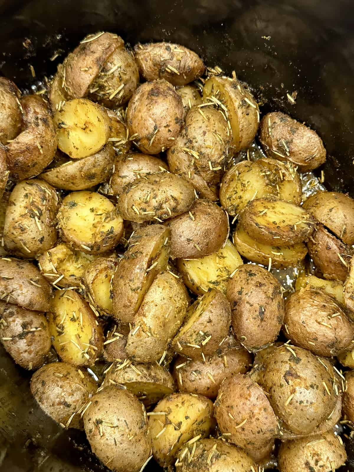 crock pot baby potatoes mixed with herbs 