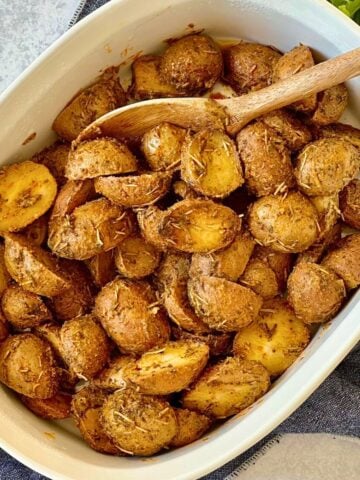 slow cooker baby potatoes with herbs in a casserole dish