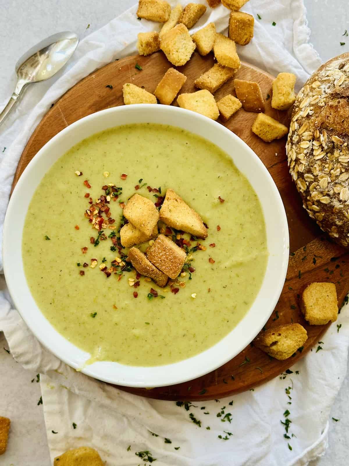 leek and potato soup in a white bowl topped with croutons