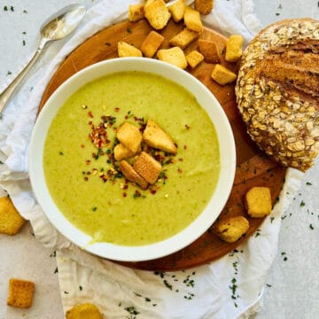 slow cooker leek and potato soup in a white bowl topped with croutons