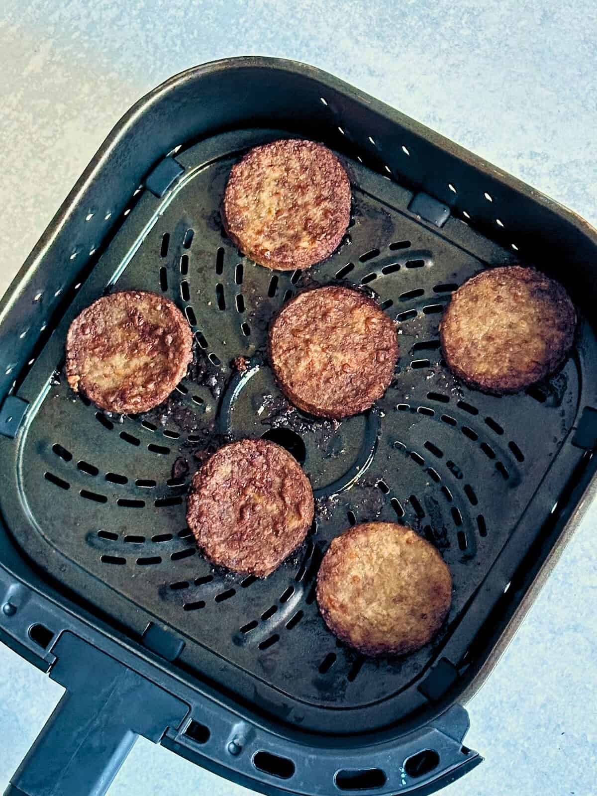 sausage patties in an air fryer basket