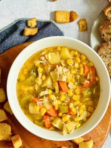 slow cooker chicken and corn soup in a white bowl with croutons