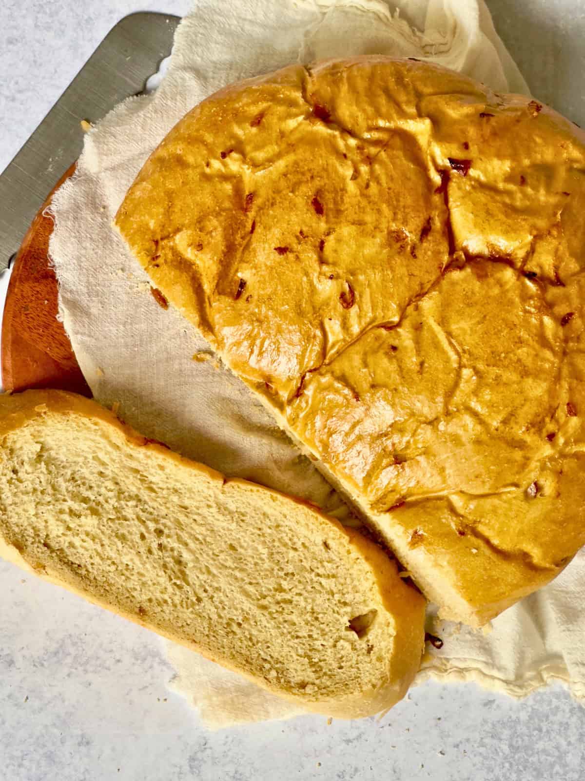 sliced bread machine onion bread on a wooden trivet