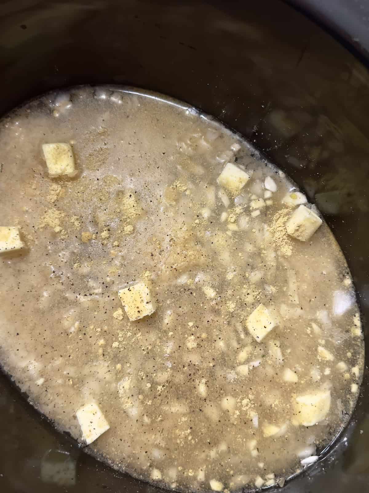 butter and broth with rice in a slow cooker