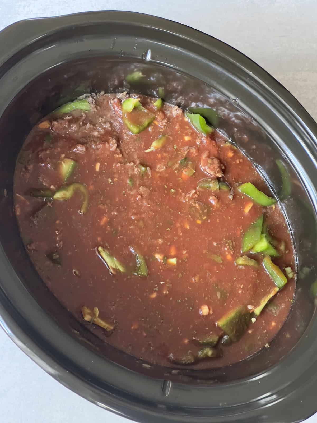 beef, rice, peppers and sauce in a slow cooker