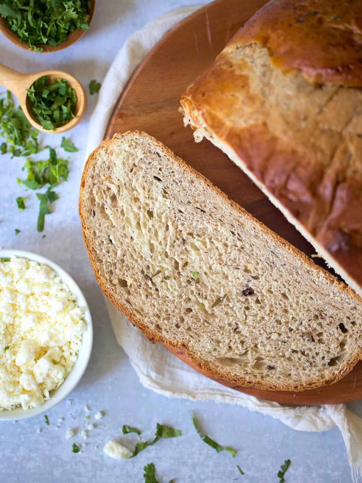 bread machine olive bread sliced on a wooden board