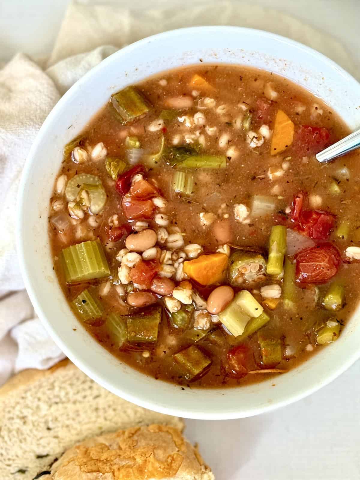 instant pot vegetable farro soup in a white bowl with bread