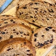 whole wheat cinnamon raisin bread sliced on a cutting board