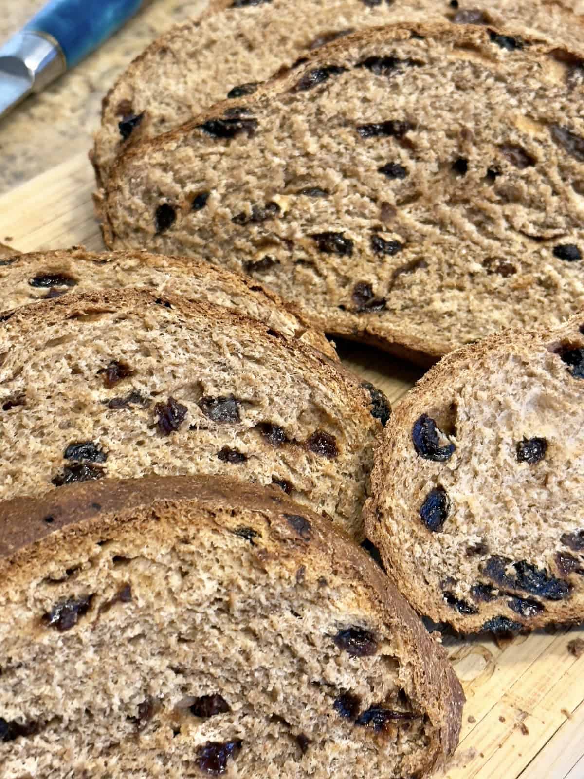 whole wheat cinnamon raisin bread sliced on a cutting board
