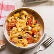 greek tortellini salad in a white bowl