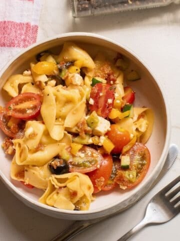 greek tortellini salad in a white bowl