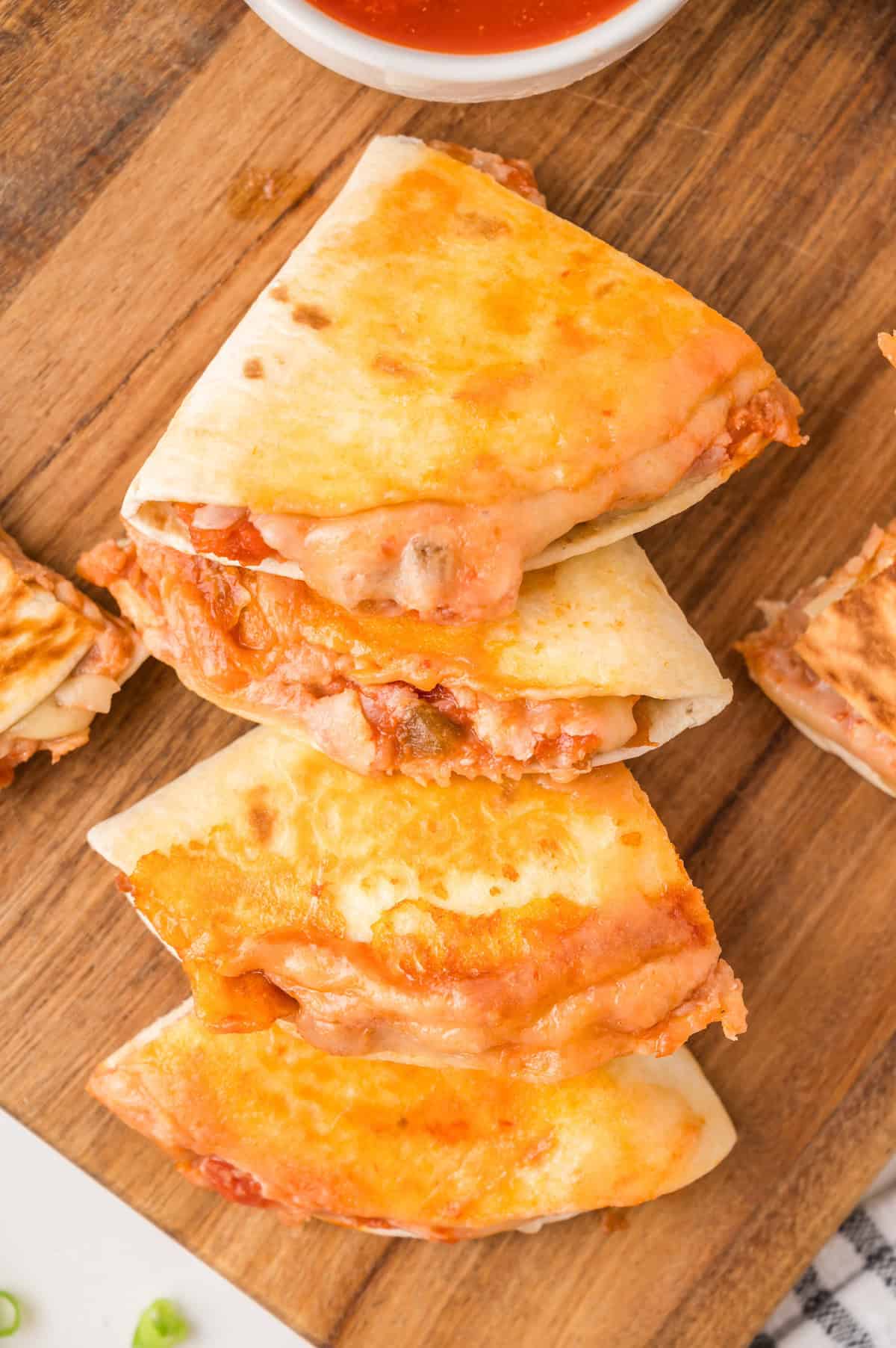 crispy sliced bean and cheese quesadillas on a cutting board