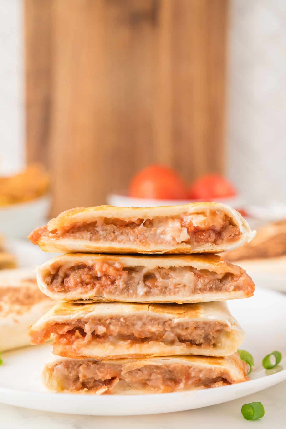 a stack of bean and cheese quesadillas on a white plate