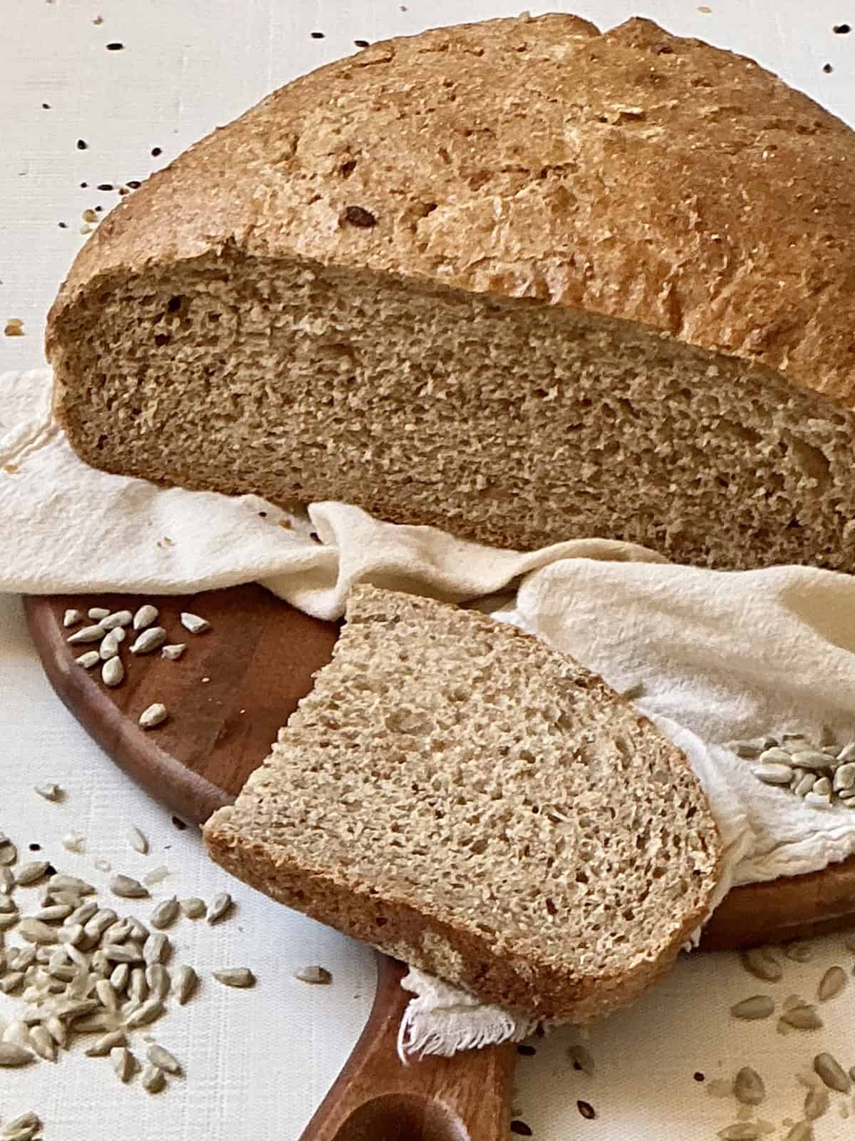 sunflower seed bread loaf sliced on a serving board