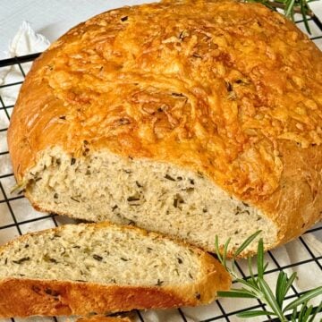 Italian herb and cheese bread on a cutting rack