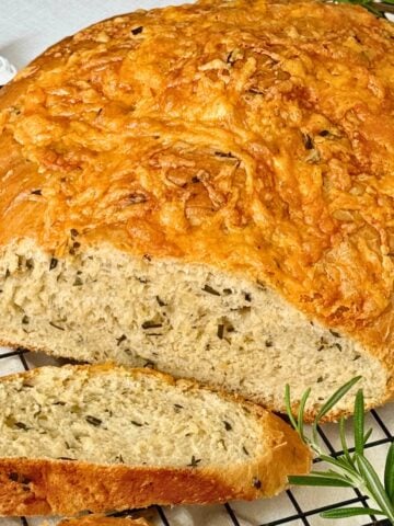 Italian herb and cheese bread on a cutting rack