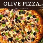 homemade olive pizza on a pizza stone