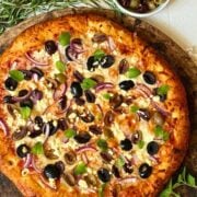 olive pizza on a pizza stone