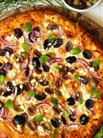 olive pizza on a pizza stone