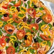 veggie supreme pizza on a pizza peel