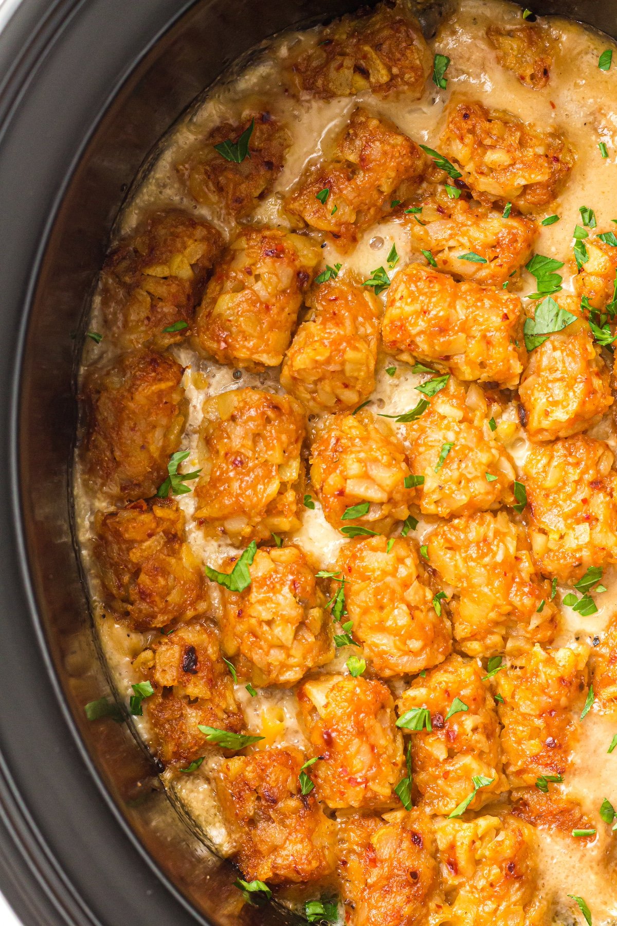 slow cooked cowboy casserole in a crockpot topped with tater tots