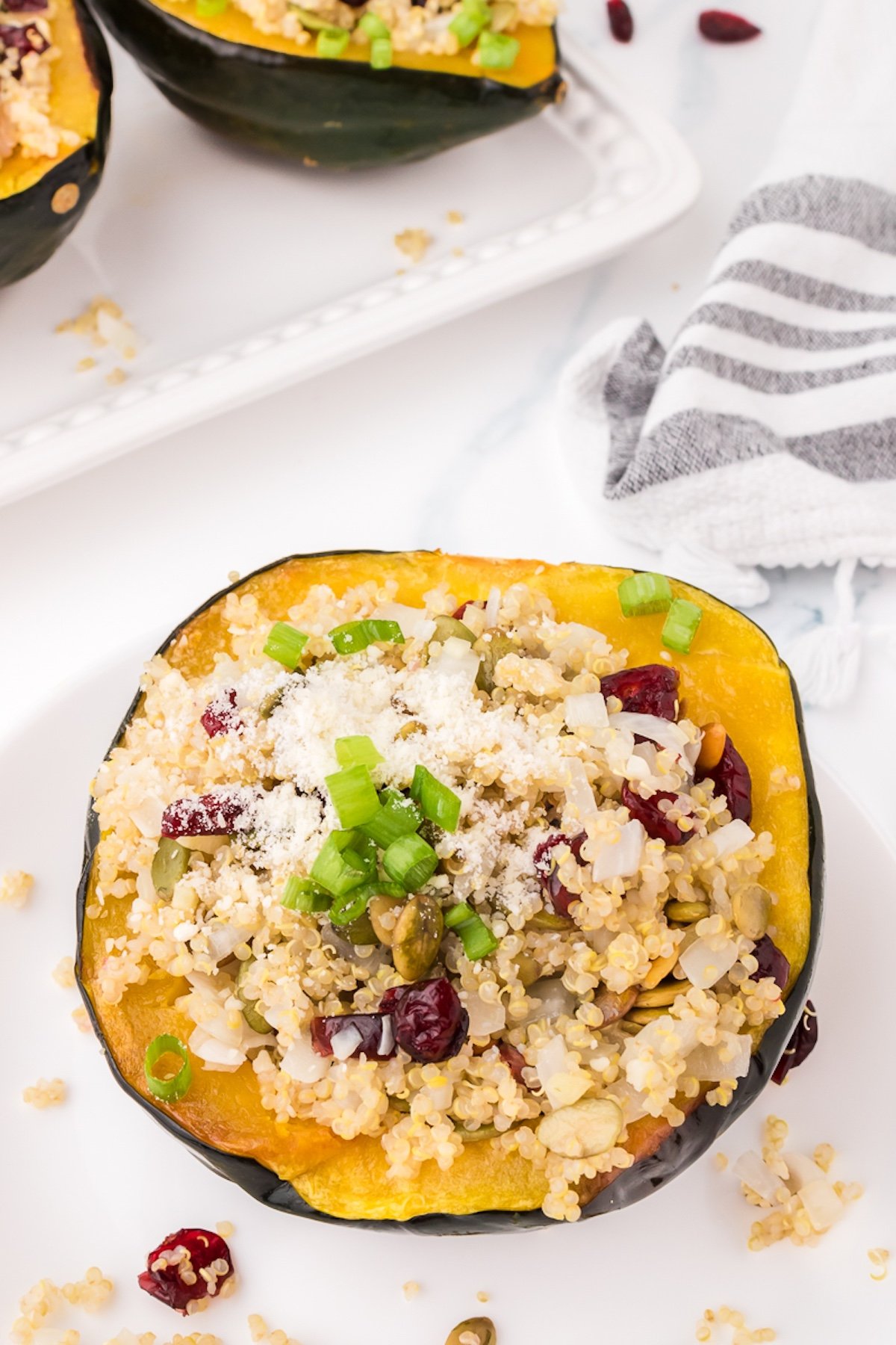 close up of a vegetarian stuffed acorn squash half on a white plate