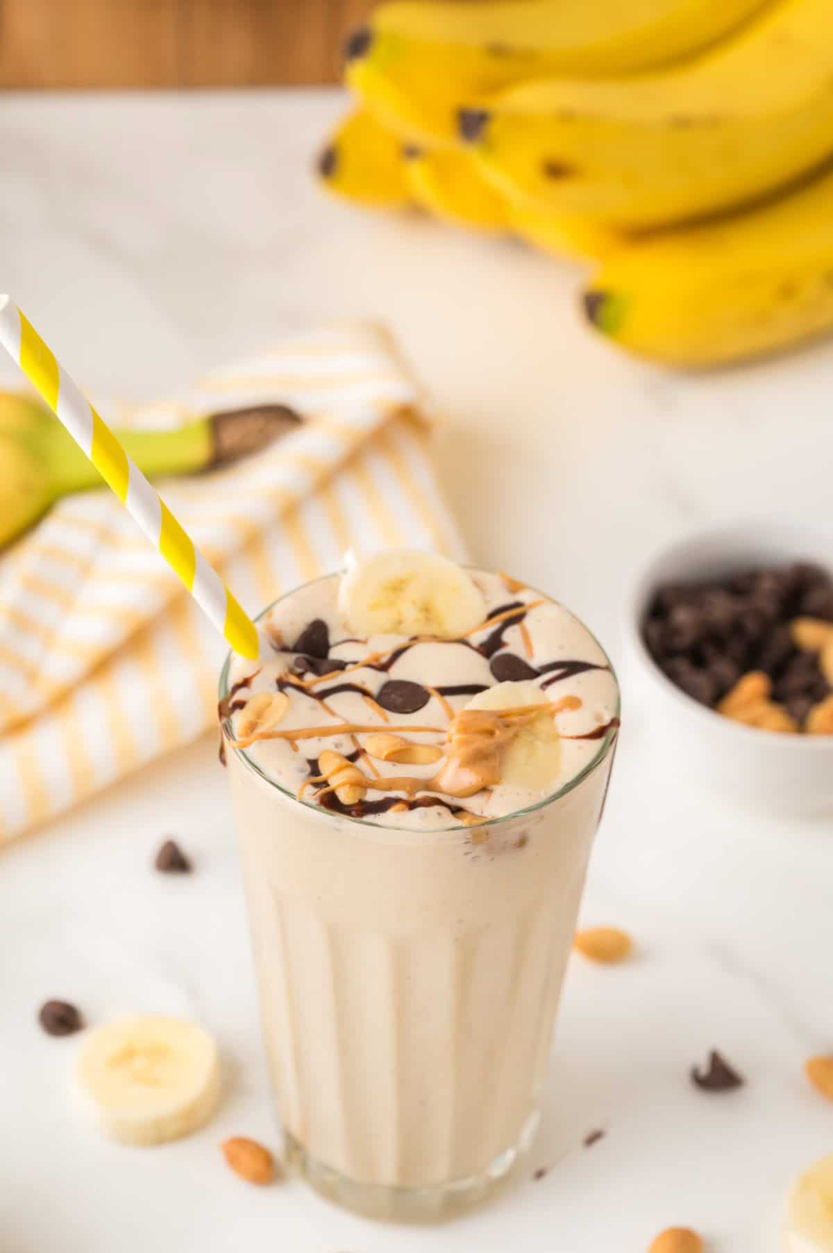 peanut butter banana milkshake topped with chocolate and peanuts in a glass