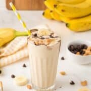 peanut butter banana milkshake topped with chocolate in a glass cup