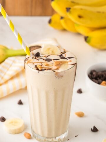 peanut butter banana milkshake topped with chocolate in a glass cup