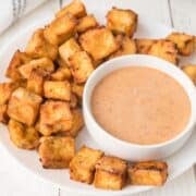 crispy air fried tofu nuggets on a plate with dipping sauce