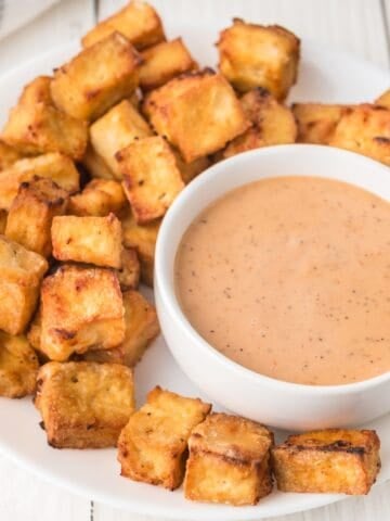 crispy air fried tofu nuggets on a plate with dipping sauce