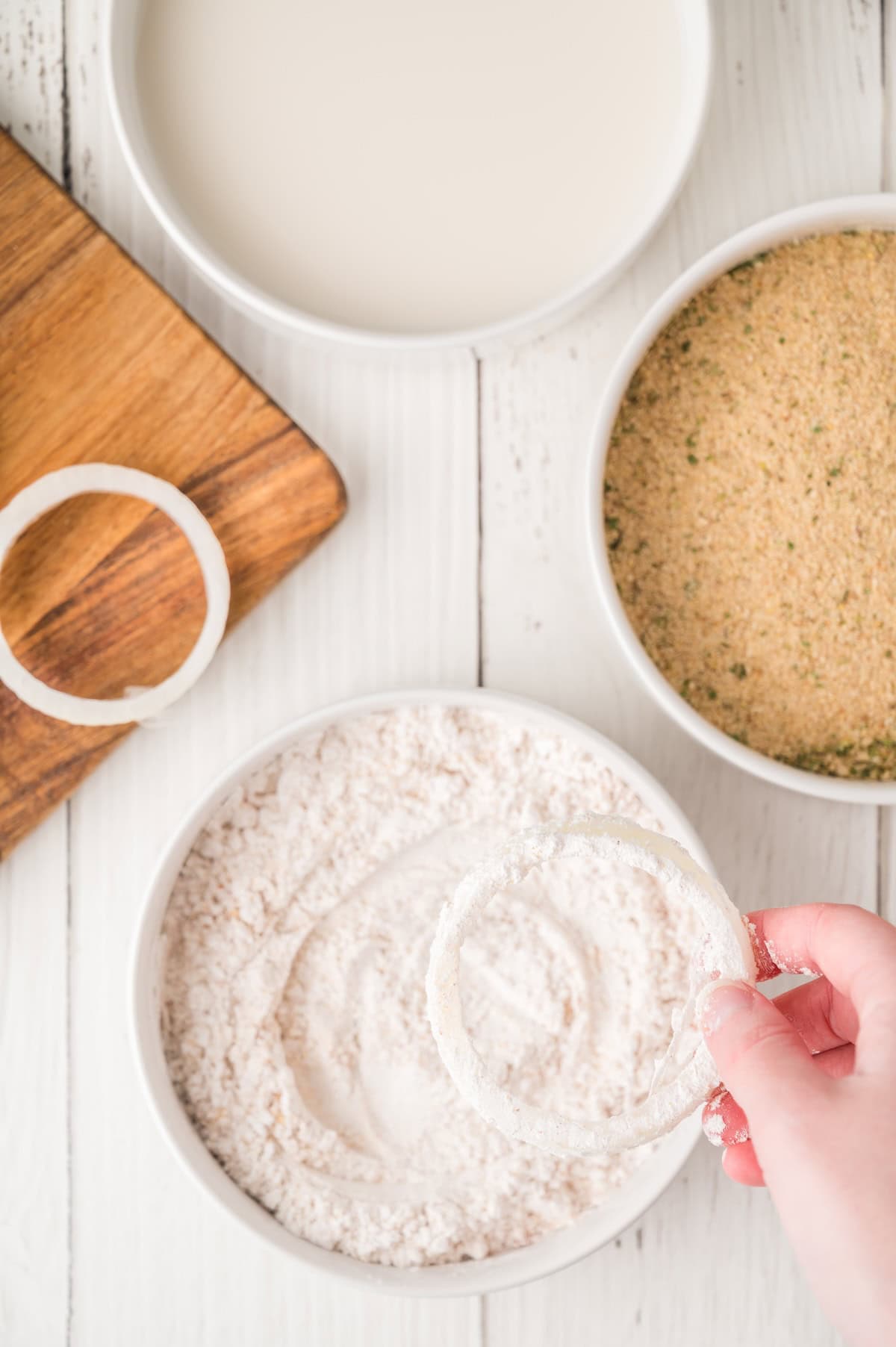 onion rings being dipped into flour