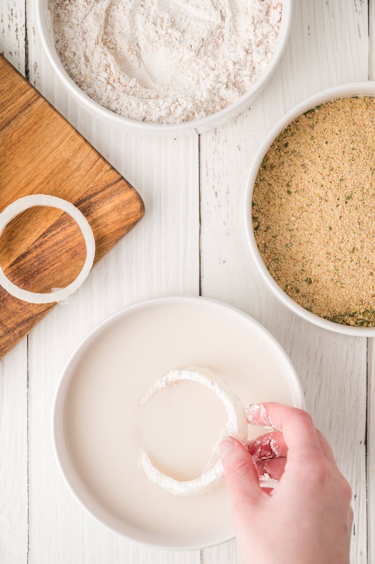 onion rings being dipped into milk