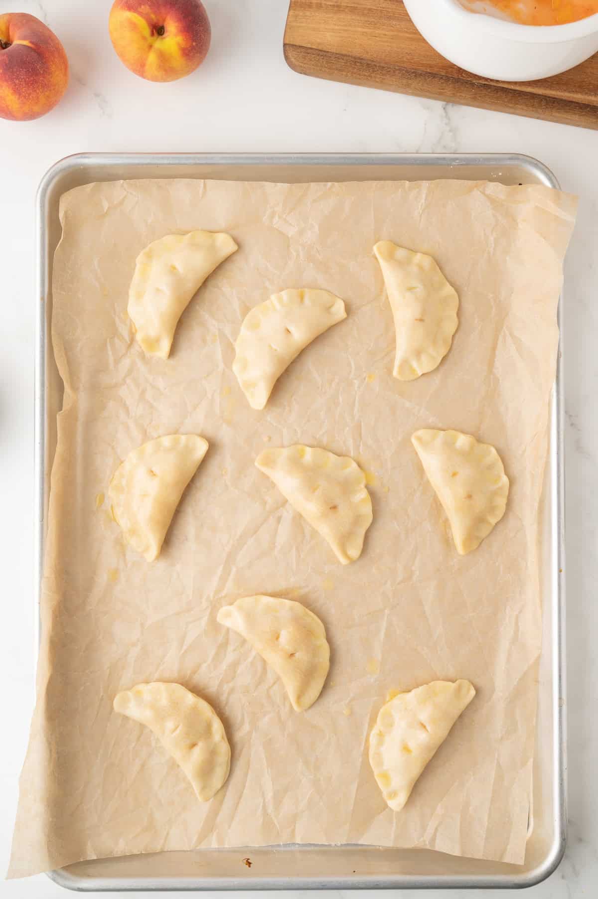 sealed mini hand pies on a baking sheet