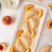 peach hand pies with glaze on a white plate