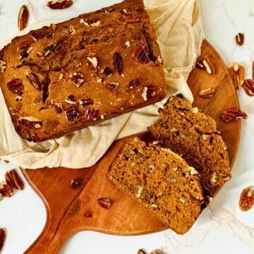 pumpkin pecan bread sliced on a cutting board