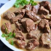 slow cooker beef tips with gravy in a white bowl