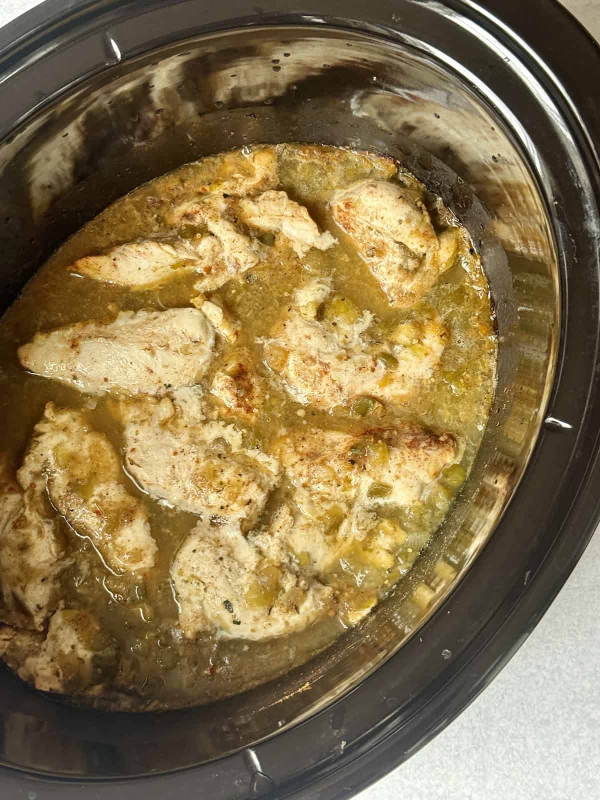 uncooked salsa verde chicken in a slow cooker