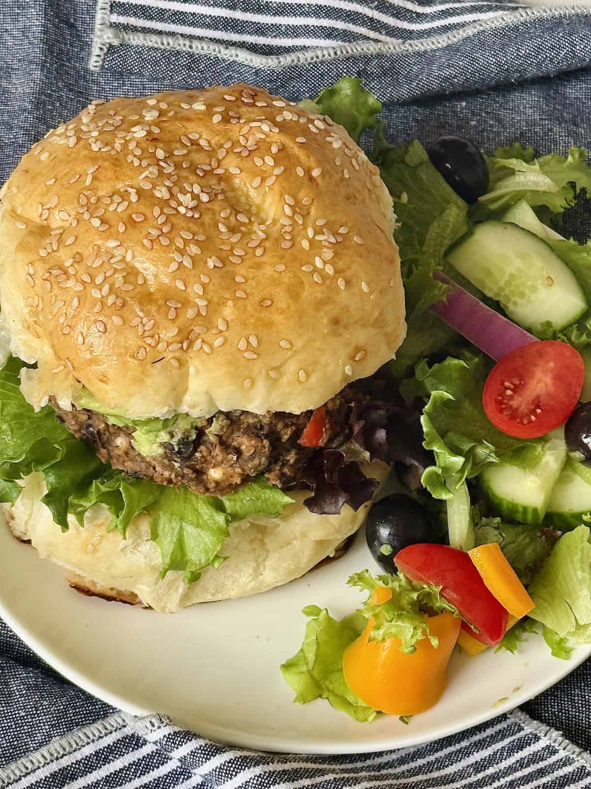 black bean burger on a hamburger bun with salad