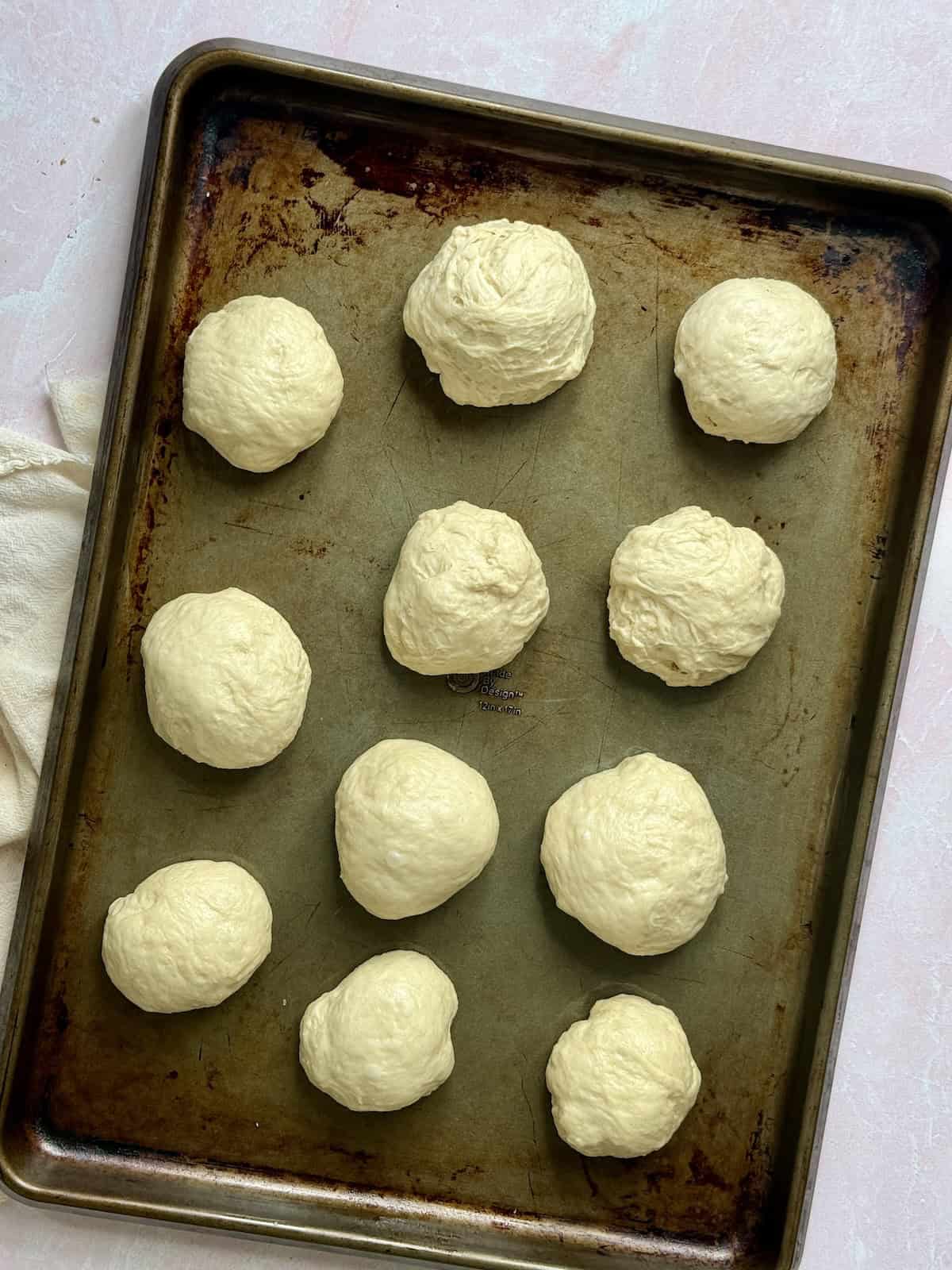 hamburger dough balls on a baking sheet