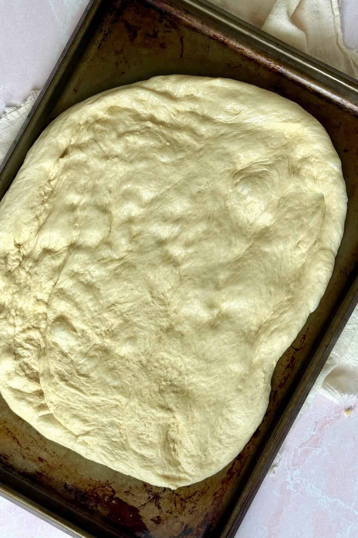 flattened dough on a baking sheet