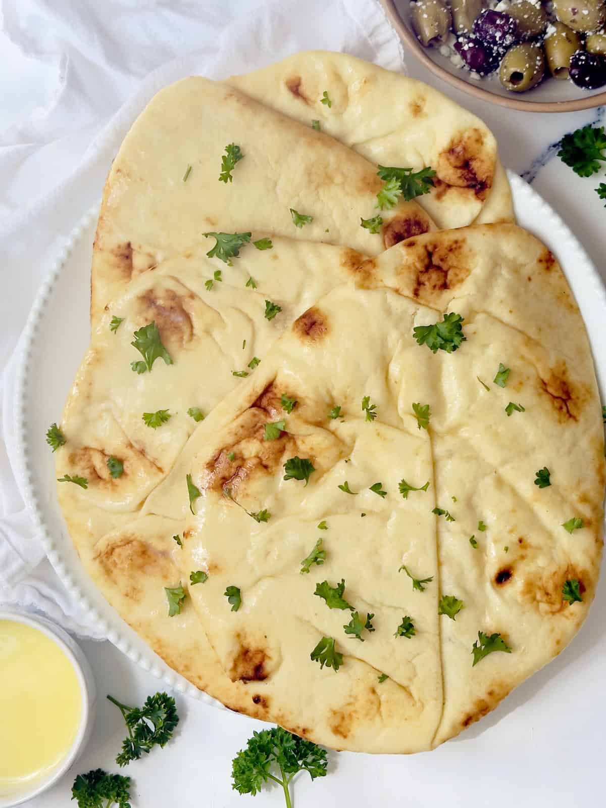 naan bread in a stack on a white plate