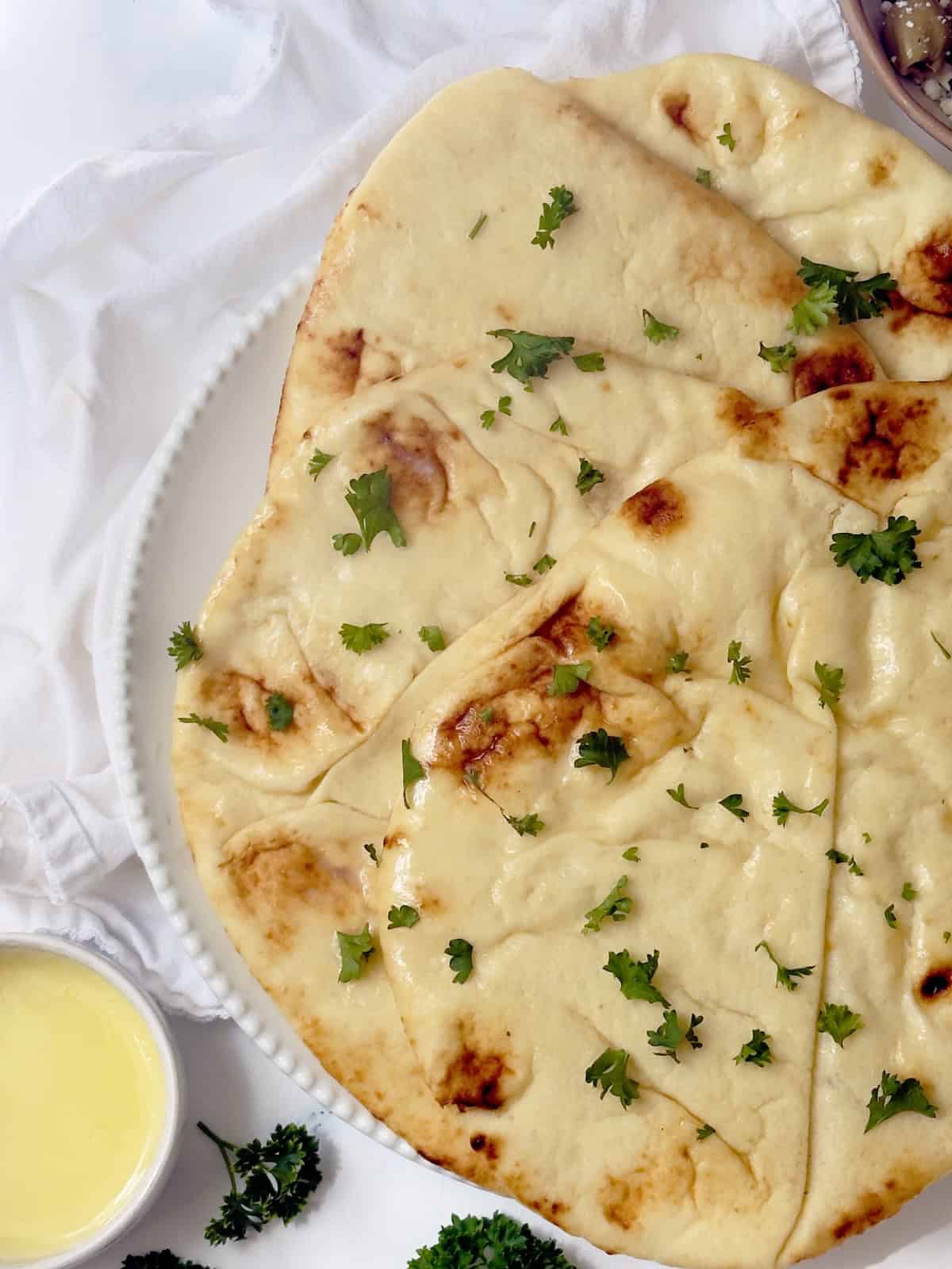 close up of buttery naan bread on a plate